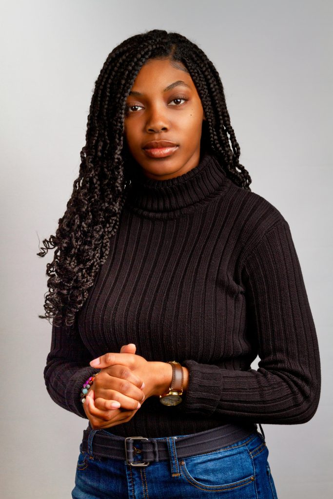 Elegant portrait of a stylish African American woman in a turtleneck sweater, showcasing modern fashion.